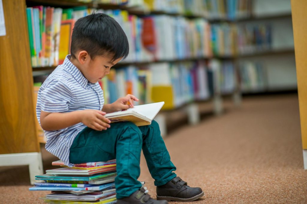 Boy reading a book in library